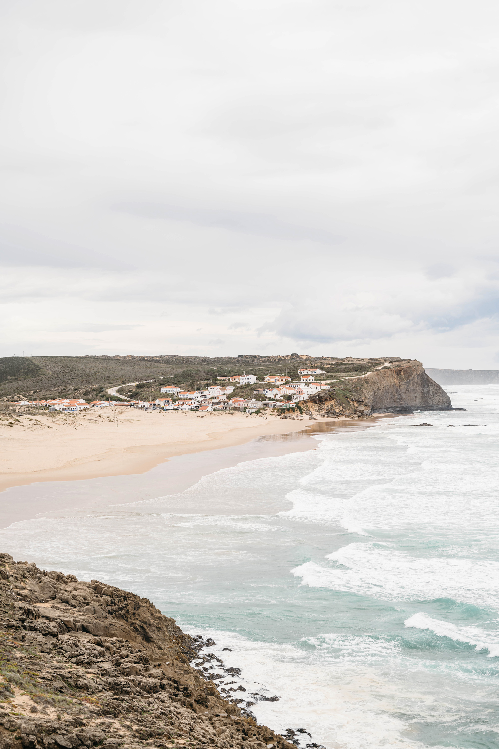 Image of shore with houses overlooking in distance.